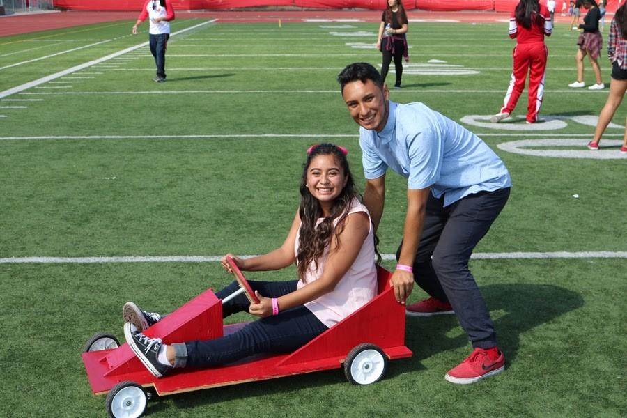Seniors Jessica Antunez and Victor Lirra pose on a box kart before their homecoming performance. 