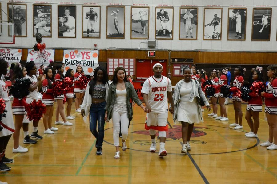 Senior Tracy Evans walks with his family and friends on Senior Night.